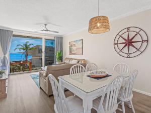 a living room with a table and chairs and a couch at Bella Vista Unit 10 19 Shoal Bay Road in Shoal Bay