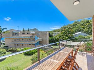 a balcony with a wooden table and chairs at Bella Vista Unit 10 19 Shoal Bay Road in Shoal Bay