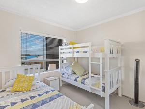 a bedroom with two bunk beds and a window at Bella Vista Unit 10 19 Shoal Bay Road in Shoal Bay
