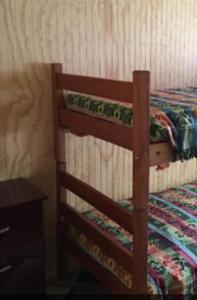 a wooden bunk bed in a room with a table at Cabañas a Cuadras Laguna Quillón in Quillón