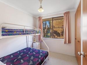a bedroom with a bunk bed and a window at Kurranulla Unit 5 15 Weatherly Close in Nelson Bay