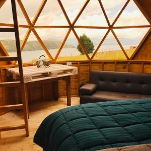 Habitación con cama, mesa y ventana en Lago De Tota Glamping, en Tota