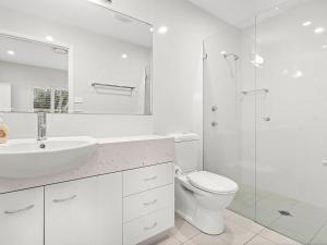 een witte badkamer met een wastafel en een toilet bij Boulder Bay Rd 1 2 Fingal Bay in Fingal Bay
