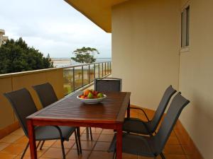 een tafel met stoelen en een fruitschaal op een balkon bij Breakwater 102 Shoal Bay in Shoal Bay