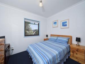 Schlafzimmer mit einem Bett und einem Fenster in der Unterkunft Carindale Unit 21 19 Dowling Street in Nelson Bay