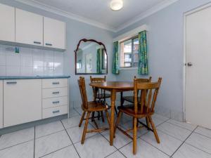 a kitchen with a wooden table and chairs at Castaways Unit 1 17 Shoal Bay Road in Shoal Bay +4 photos