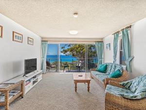 a living room with a couch and a television at Luskin Lodge Unit 10 29 Weatherly Close in Nelson Bay