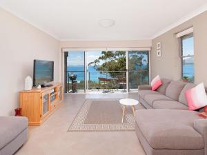 a living room with a couch and a tv at Luskin Lodge Unit 15 29 Weatherly Close in Nelson Bay