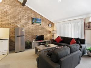 - un salon avec un canapé et un réfrigérateur dans l'établissement Macadamia Court 2 8 Government Road, à Nelson Bay