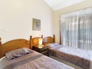- une chambre avec 2 lits et une fenêtre avec une lampe dans l'établissement Macadamia Court 2 8 Government Road, à Nelson Bay
