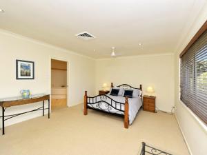 Schlafzimmer mit einem Bett, einem Schreibtisch und einem Fenster in der Unterkunft Marine Dr 2 70 Fingal Bay in Fingal Bay