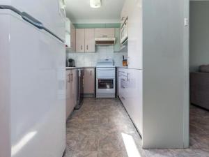 a small kitchen with white cabinets and appliances at Marine Drive 32 in Fingal Bay