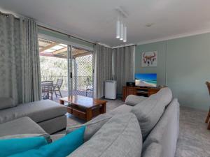 a living room with a couch and a table at Marine Drive 32 in Fingal Bay