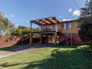 a house with a deck on the side of it at Marine Drive 32 in Fingal Bay
