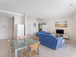 - un salon avec un canapé bleu et une table dans l'établissement Mirage 1 24 Gloucester Street, à Nelson Bay