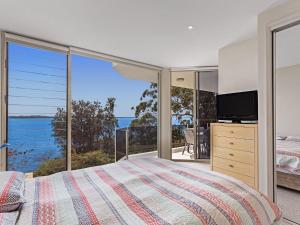 a bedroom with a bed and a view of the ocean at Mirage 1 24 Gloucester Street in Nelson Bay