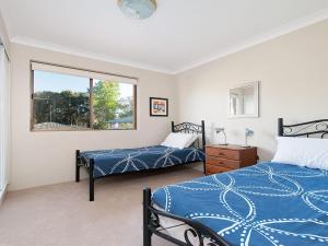 a bedroom with two beds and a window at Misthaven Unit 1 12 Mistral Close in Nelson Bay
