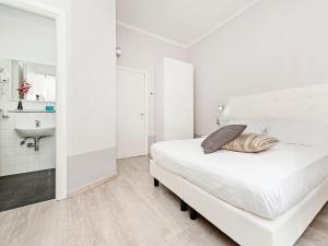 a white bedroom with a bed and a bathroom at White Rooms Colosseo in Rome