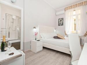 a white bedroom with a bed and a bathroom at White Rooms Colosseo in Rome