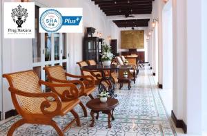 チェンマイにあるピンナカラ ブティックホテル＆スパの廊下の椅子とテーブルのあるレストラン