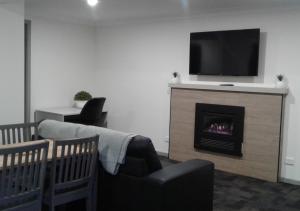 a living room with a fireplace with a flat screen tv at Snow Gum Apartment 2 in Baw Baw Village