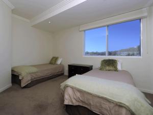 1 dormitorio con 2 camas y ventana grande en Oasis Unit 9 5 Laman Street, en Nelson Bay