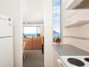 a kitchen with white appliances and a view of the ocean at Ocean Shores Unit 10 27 Weatherly Close in Nelson Bay