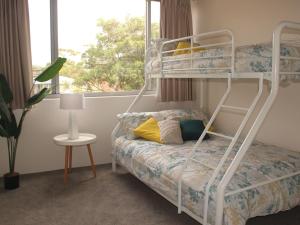 a bedroom with a bunk bed and a window at Ocean Shores Unit 10 27 Weatherly Close in Nelson Bay