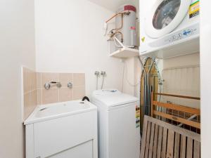 a laundry room with a sink and a washing machine at Ocean Shores Unit 10 27 Weatherly Close in Nelson Bay