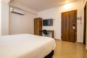 a hotel room with a bed and a television at Hotel Amoek in Cartagena de Indias