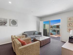 un soggiorno con 2 sedie e un divano di Pacific Blue Adjoining Apartments 244A and 244B 265 Sandy Point Rd a Salamander Bay
