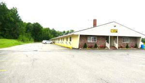 a building with a car parked in front of it at Budget Host Airport Inn in Waterville