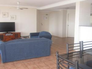 a living room with a blue couch and a tv at Palm Beach 33B Shoal Bay Road in Shoal Bay
