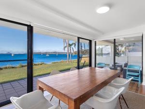 a dining room with a wooden table and chairs at Panarea Soldiers Point Road Unit 1 197 in Salamander Bay