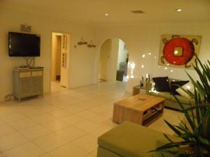 a living room with a couch and a tv at Pelicans Perch 8 Verona Road in Shoal Bay