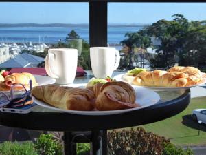 two plates of pastries on a table with a view at Portside Unit 12 1 Donald Street in Nelson Bay