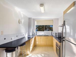a kitchen with a black counter and a window at Portside Unit 8 1 Donald Street in Nelson Bay