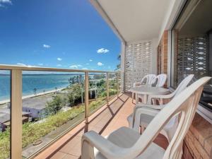 a balcony with white chairs and a view of the ocean at Quarterdeck Unit 3 12 Magnus Street in Nelson Bay