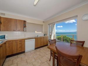 a kitchen with a table and a large window at Quarterdeck Unit 3 12 Magnus Street in Nelson Bay