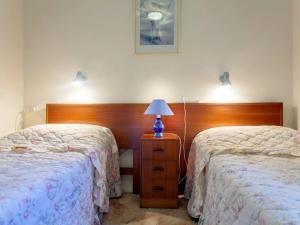 a bedroom with two beds and a lamp on a night stand at Quarterdeck Unit 3 12 Magnus Street in Nelson Bay