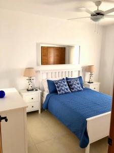 a bedroom with a blue bed and two night stands at Bayahibe Apartment in Cadaques in Bayahibe