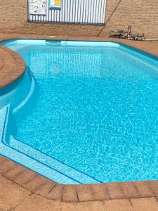 a swimming pool with blue water in a building at All Seasons Motor Lodge in Dubbo