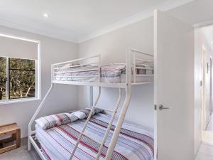 two bunk beds in a white room with a window at Collendina Unit 6 19 Kurrawa Close in Nelson Bay