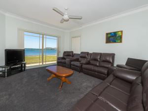 a living room with a couch and a television at Cook Street 4 in Salamander Bay