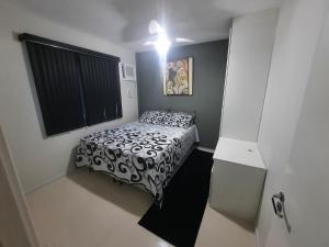 a small bedroom with a black and white bed at Porto Real Resort Suites Angra in Mangaratiba