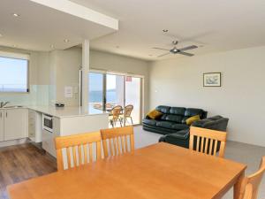 a kitchen and living room with a table and a couch at Del Rae Unit 12 25 Shoal Bay Road in Shoal Bay
