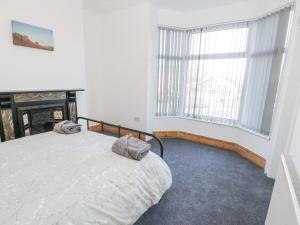 a bedroom with a bed and a fireplace and a window at Hilderthorpe House in Bridlington