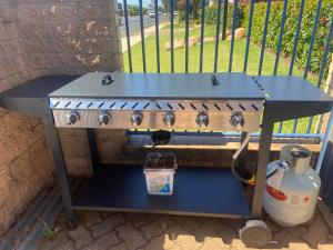 a bbq grill with a blue top on a table at All Seasons Motor Lodge in Dubbo