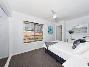 una camera da letto bianca con un letto e una finestra di Eden by the Bay 98 Sandy Point Road a Corlette
