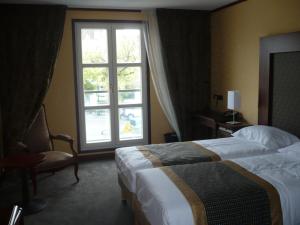 a hotel room with a bed and a window at Hotel De France in Montargis
